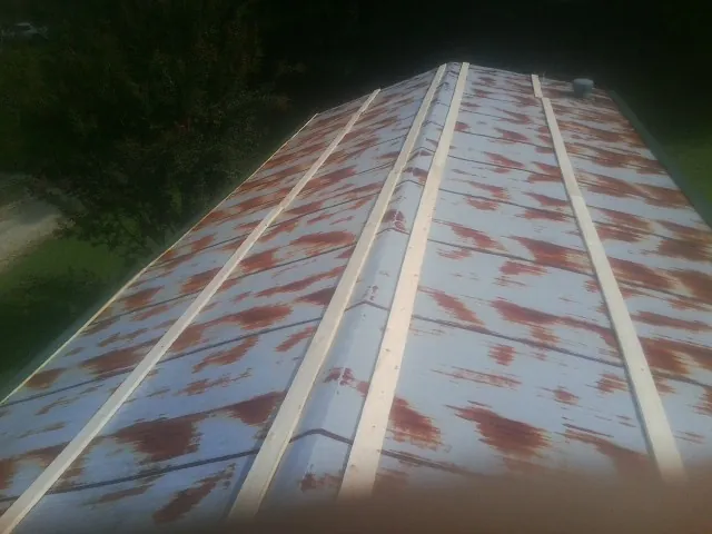 Rusted metal roof panels with new wood purlins before replacement — Storm Damage Roof Repair in Washoe Valley by Roofing Brothers