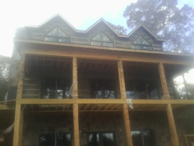 Dormers and porch framing on a large log home under construction — Roof Coating work by our crew in Washoe Valley
