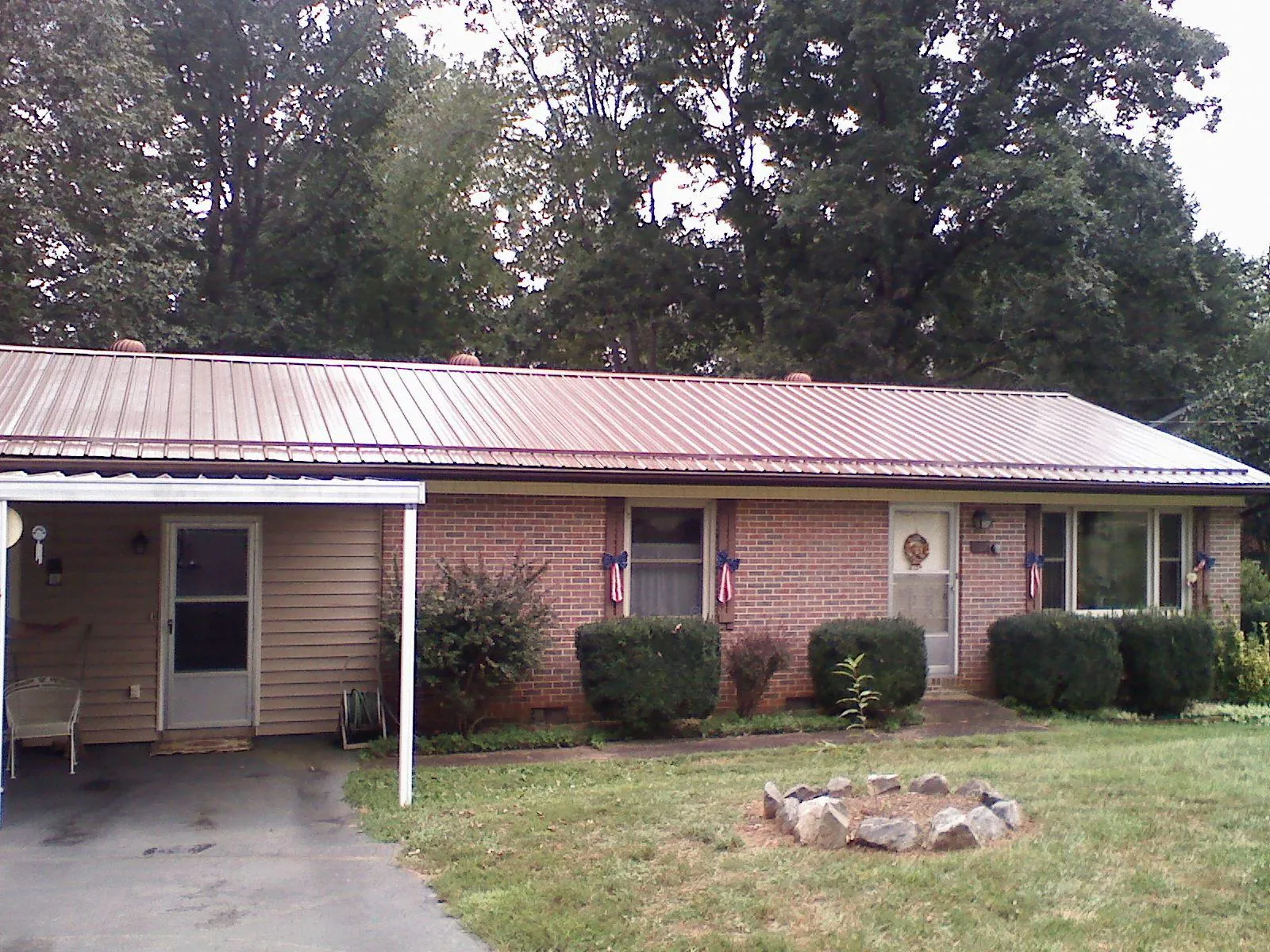 Bronze metal roof and carport on a brick ranch home — Roof Repair work by our crew in Washoe Valley